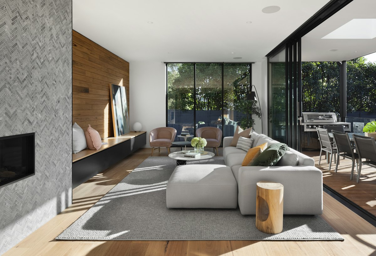 Open living space with a walnut feature wall and floor-to-ceiling windows