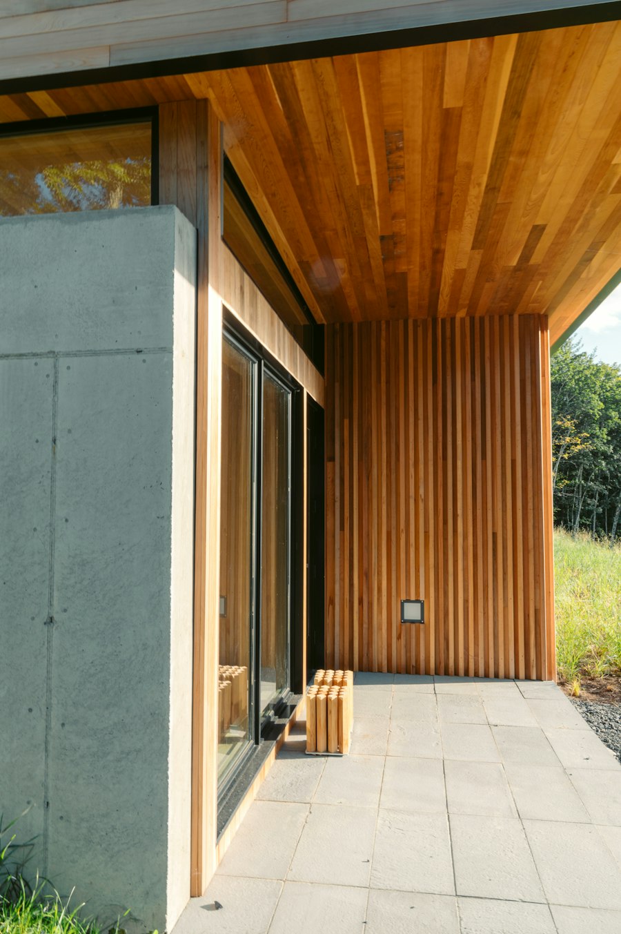 Entrance with a slatted wooden bench beside a tall timber door