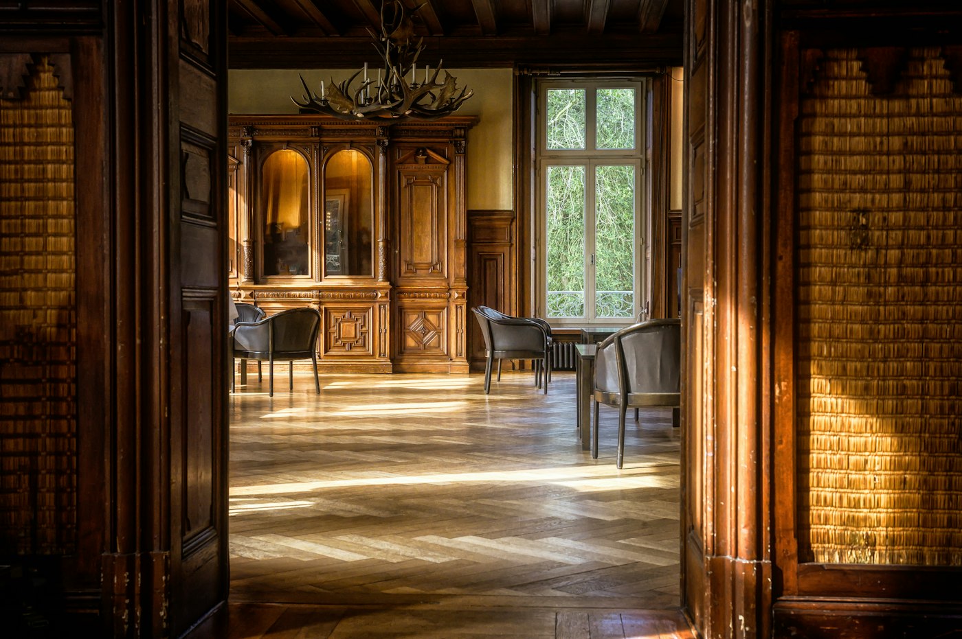 Timber-panelled hall opening into a sunlit dining room